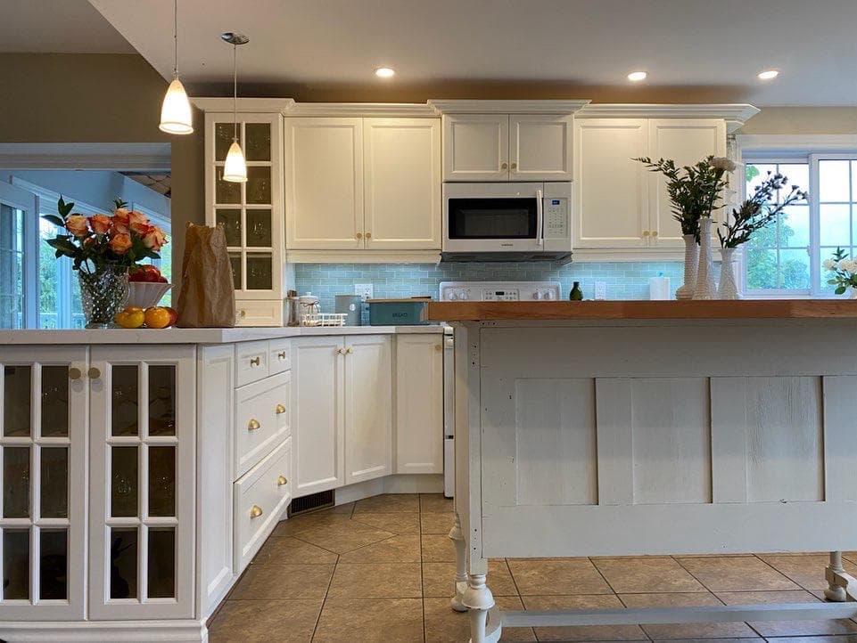 White kitchen cabinetry with an island and a professionally renewed finish